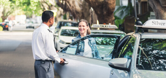 driver opens the taxi door for passenger