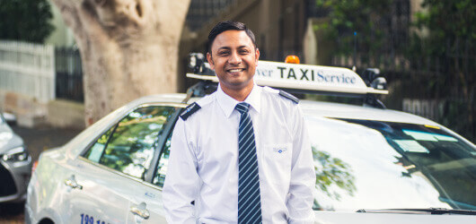 man smiling in front of Silver Service taxi